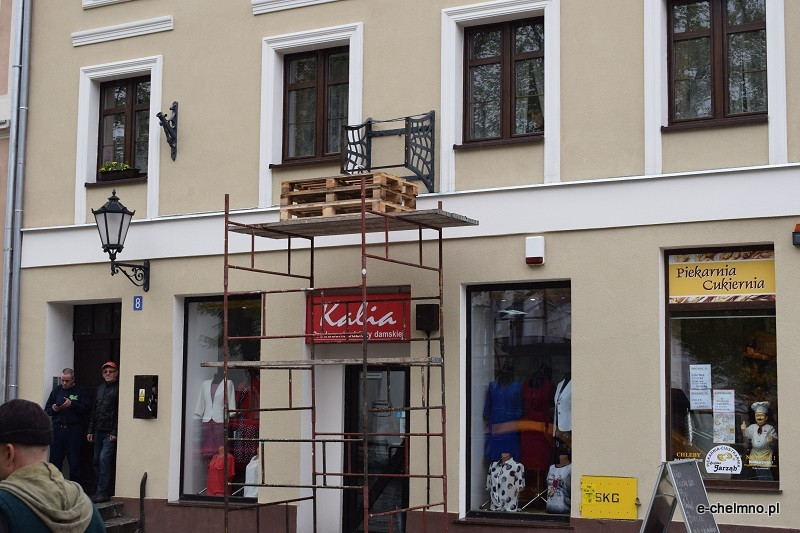 Montaż naprawionego zabytkowego zegara na kamienicy przy Rynku