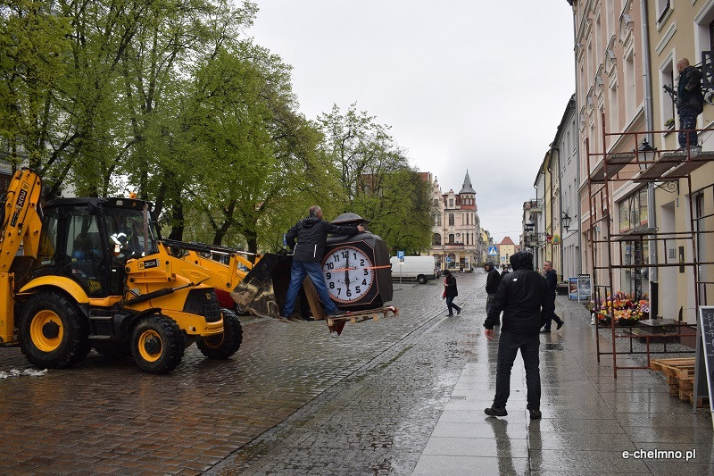 Montaż naprawionego zabytkowego zegara na kamienicy przy Rynku