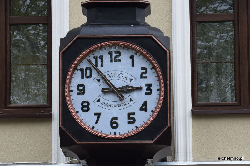 Montaż naprawionego zabytkowego zegara na kamienicy przy Rynku